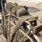 A bicycle with a cloth-covered item strapped to the rear rack.