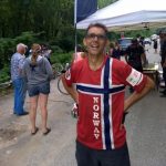 A man in a Norway jersey stands with other people nearby
