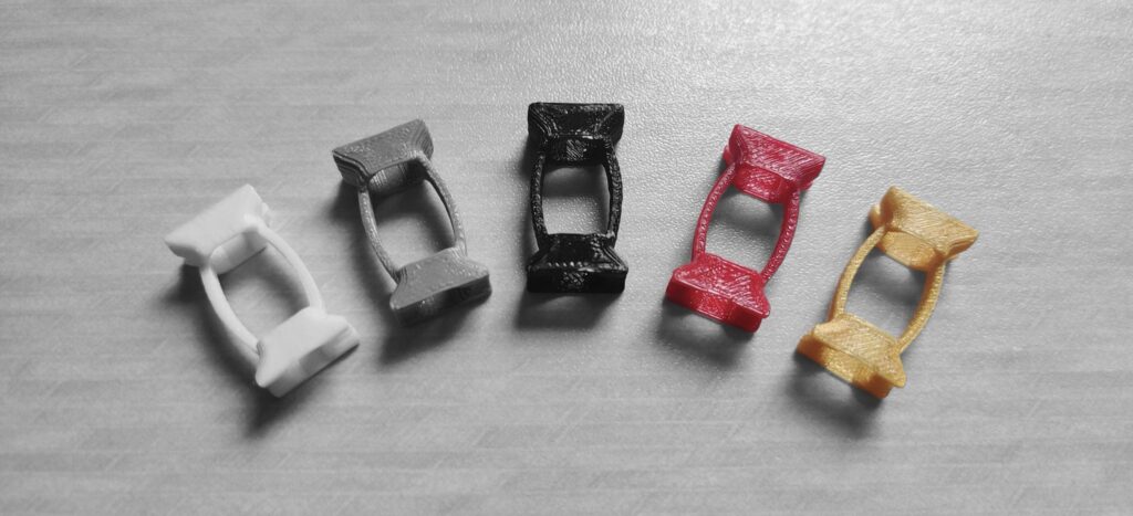 Various colors of the EZ clamp spring on a gray background.